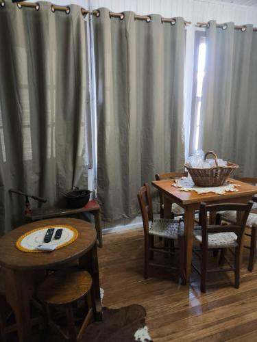 un comedor con mesas, sillas y cortinas en Recanto do Zeca, en Bento Gonçalves
