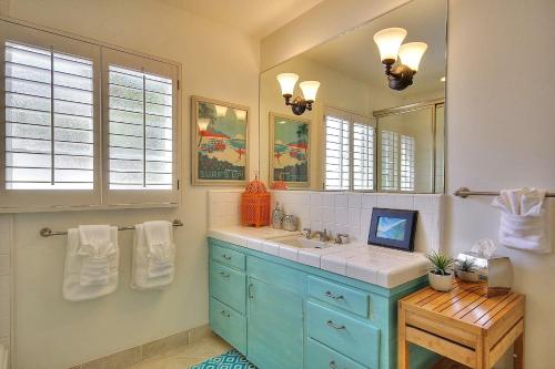 Un baño con un lavabo azul y un espejo. en West Beach Villa 2, en Santa Bárbara