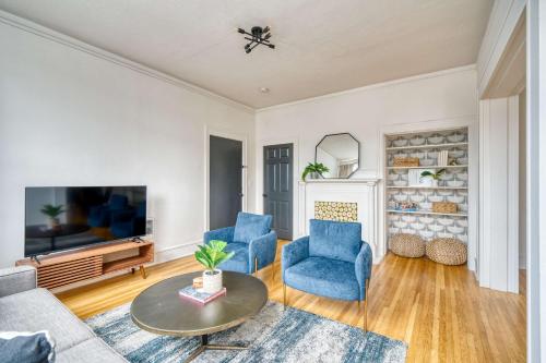 a living room with blue chairs and a tv at Stay Portland - La Casa Burnside - Local Eateries, Shops, and Bars in Portland