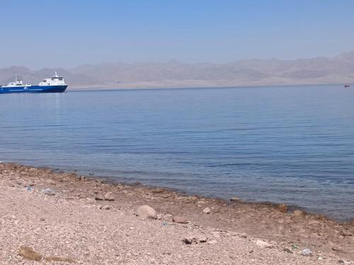 a boat in the water next to a beach at مخيم مبروكه in Nuweiba‘ el Muzeinah