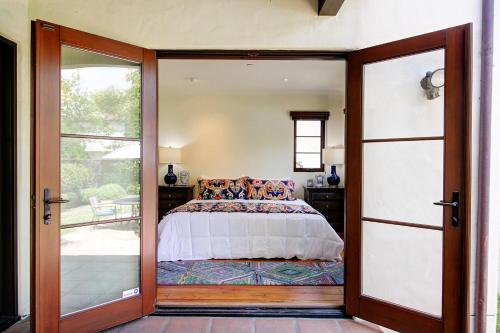 Un dormitorio con una cama y una puerta corrediza de vidrio. en West Beach Villa 5 & 6, en Santa Bárbara