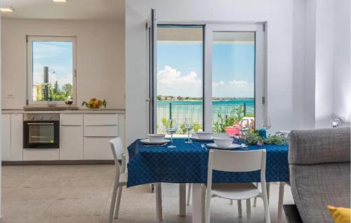 a dining room with a table and a view of the ocean at Nice Home In Privlaka in Glavan