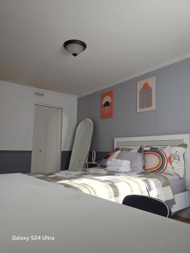 a bedroom with a large bed and two chairs at Appartement, Jacuzzi, Spa et terasse in Longueuil