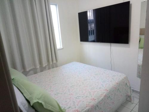 a bedroom with a bed and a flat screen tv at Ap confortável e Aconchegante in Petrolina