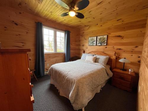 ein Schlafzimmer mit einem Bett in einer Blockhütte in der Unterkunft Stanhope Cottages in Stanhope