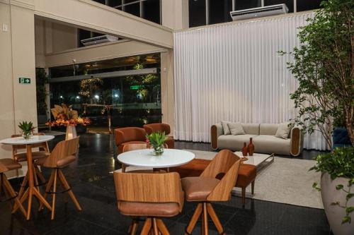 a lobby with tables and chairs and a couch at Amazon Park Hotel in Belém