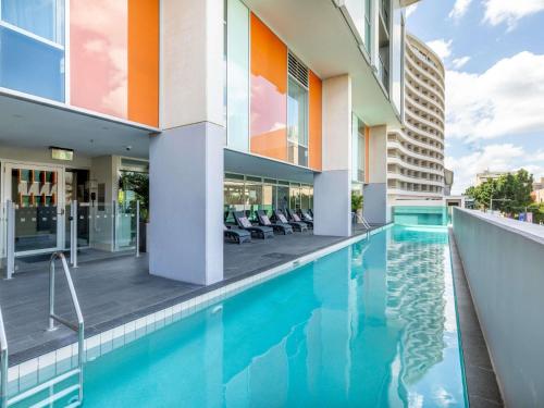 a swimming pool next to a building at Mantra South Bank Brisbane in Brisbane