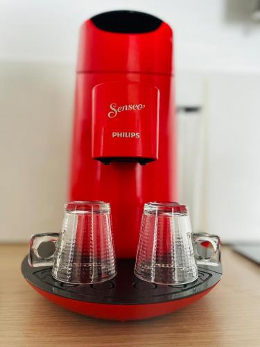 una caffettiera rossa con due tazze su un vassoio di Appartement Confortable a Le Grau-du-Roi