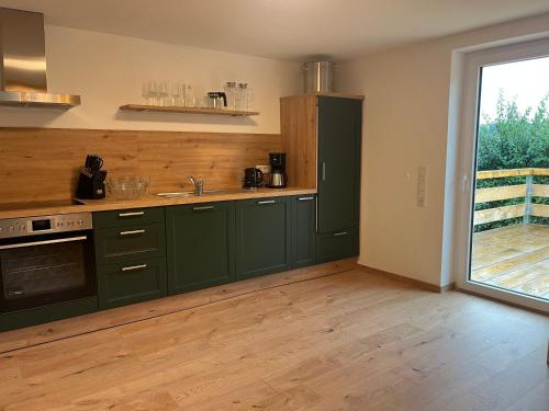 an empty kitchen with green cabinets and a window at 4-Steine-Blick, Wohnung 1 in Schöna