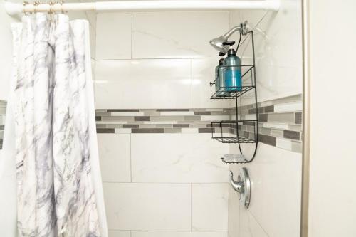 a shower with a blue bottle on a shower curtain at Serene Studio Retreat in Jacksonville