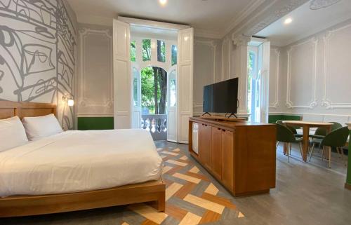 a bedroom with a bed and a flat screen tv at Hotel MX condesa CDMX, Trademark Collection by Wyndham in Mexico City