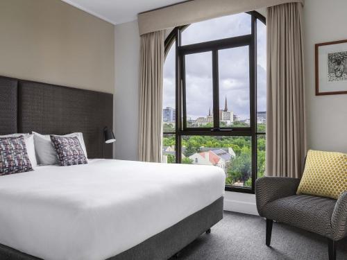 ein Hotelzimmer mit einem großen Bett und einem Fenster in der Unterkunft Mantra on Jolimont Melbourne in Melbourne