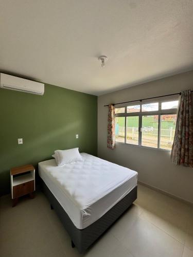 帕罗卡Morada Vista Verde的一间卧室，有一张白色的床和一扇窗户