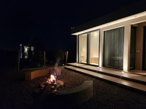 a night view of a house with a table in the yard at ENTREVID suites & spa in Anchoris