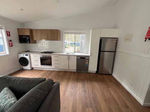 a living room with a couch and a kitchen at Tasman Holiday Parks - Kioloa Beach in Kioloa
