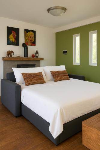 a bedroom with a large white bed with green walls at Cabaña los Robles in Gowland