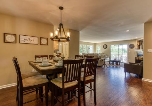 a dining room and living room with a table and chairs at Memorable "Deer & Doe" by HoneyBearCabins 4BR 3BA, Mountain View Deck, Farmhouse Decor, Fireplace, 3 Acres in Sevierville