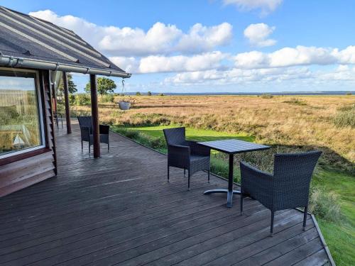 a wooden deck with chairs and a table on it at 6 person holiday home in Højslev-By Traum in Bøstrup