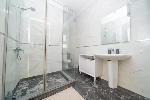 a white bathroom with a sink and a shower at Ocean Dream - Spacious Duplex with Ocean View, Astonishing Sunset - 4 Bedrooms with Balcony - WIFI, IPTV in Tangier