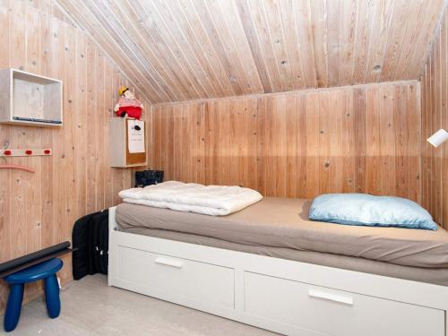 a bed in a room with a wooden wall at 6 person holiday home in Ebeltoft-By Traum in Ebeltoft