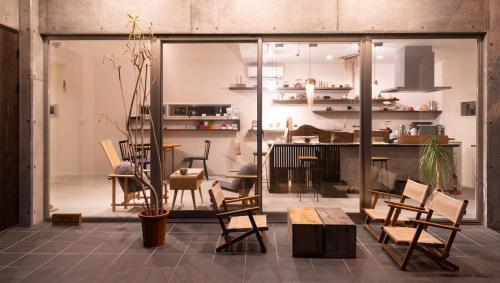 a room with chairs and a table and a kitchen at 一棟貸切鳥取の深緑に潜むモダン建築焙煎したての珈琲と休息を in Tottori