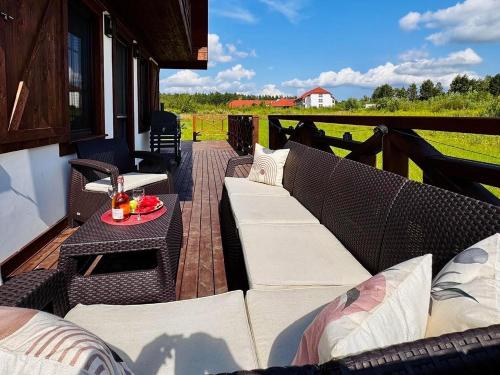 a patio with a couch and a table on a deck at Warmia Domek Bukowy in Woryty
