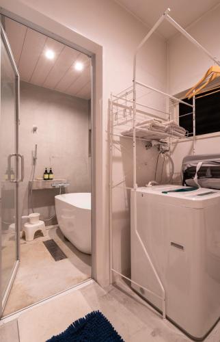 a bathroom with a tub and a toilet and a sink at 一棟貸切鳥取の深緑に潜むモダン建築焙煎したての珈琲と休息を in Tottori