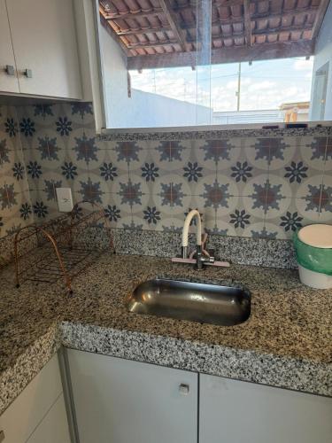 a kitchen counter with a sink and a window at Casa aconchegante e cheirosa in Nanuque