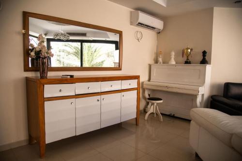 a living room with a dresser and a piano at La Villa 91 in Monastir
