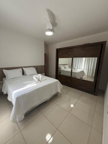 a bedroom with a bed and a large mirror at Casa aconchegante e cheirosa in Nanuque