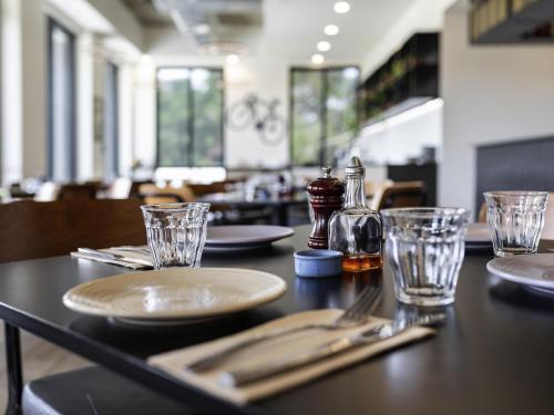 una mesa en un restaurante con platos y vasos en Mantra MacArthur Hotel, en Canberra