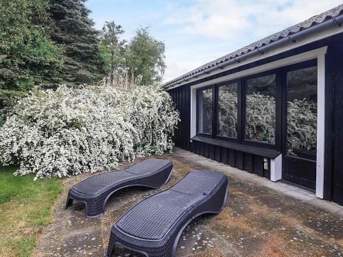 two black benches sitting outside of a house at 6 person holiday home in Gedser-By Traum in Gedser