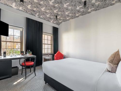a hotel room with a bed and a desk at Peppers Gallery Hotel in Canberra