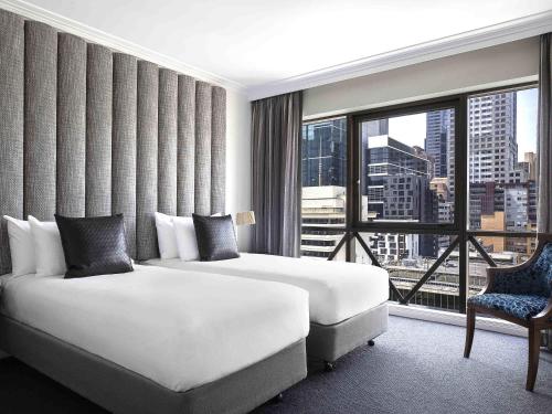 a hotel room with two beds and a large window at Mantra on Russell in Melbourne