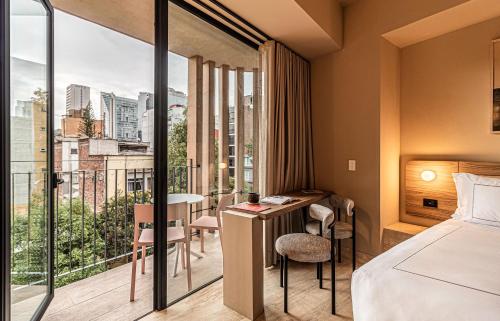 a hotel room with a bed and a balcony at Kukun Marsella Juarez in Mexico City