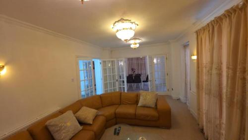 a living room with a couch and a table at First Class Luxurious Apartment London Finchley in Brent Station