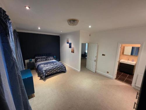 a large bedroom with a bed and a bathroom at First Class Luxurious Apartment London Finchley in Brent Station
