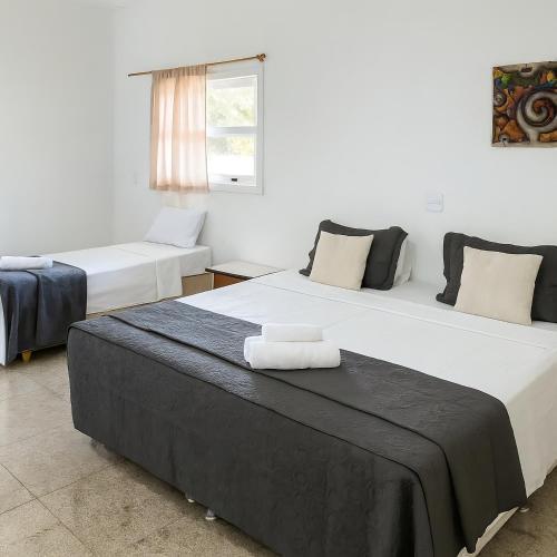 two beds sitting in a room with a window at POUSADA ARUÁ PARATY - ''Novidade'' in Paraty