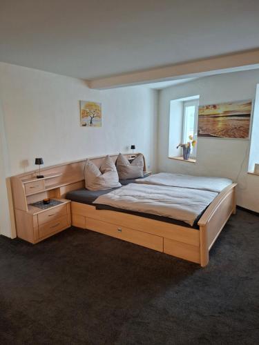een slaapkamer met een groot houten bed en een raam bij Ferienwohnung Waldblick mit Sauna in Deutschneudorf
