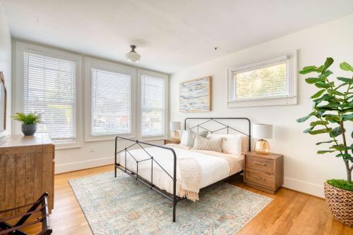 ein Schlafzimmer mit einem Bett in einem Zimmer mit Fenstern in der Unterkunft Stay Portland - La Casa Burnside - Local Eateries, Shops, and Bars in Portland