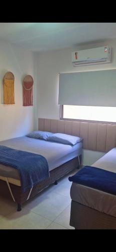 ジャパラティンガにあるCasa recém construída + piscina, próxima da praiaのベッド2台と窓のある寝室