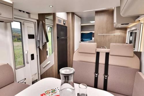 an interior of an rv with a table and chairs at Caravan Tiny House Base Camp Granada Camping in Dúrcal