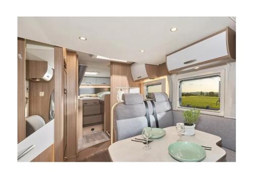 an interior view of an rv with a table and chairs at Caravan Tiny House Base Camp Granada Camping in Dúrcal