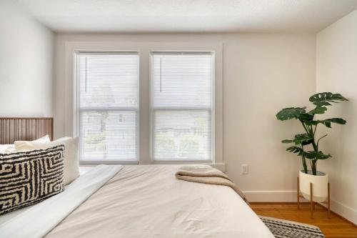 a bedroom with a large bed and two windows at Stay Portland - La Casa Burnside -Local Eateries -Shops - Bars in Portland