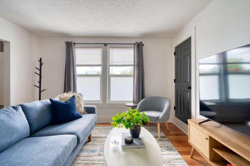 a living room with a blue couch and a table at Stay Portland - La Casa Burnside - Local Eateries, Shops, and Bars in Portland