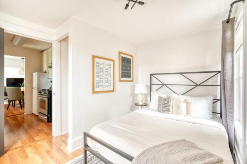 a white bedroom with a bed and a kitchen at Stay Portland - La Casa Burnside - Local Eateries, Shops, and Bars in Portland