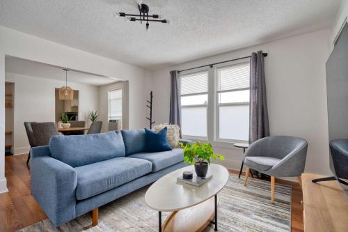 a living room with a blue couch and a table at Stay Portland - La Casa Burnside - Local Eateries, Shops, and Bars in Portland