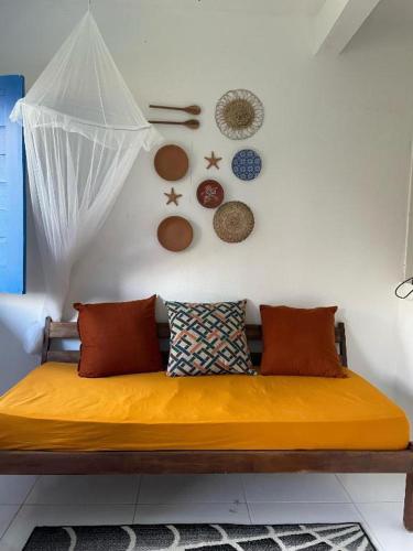 a bed in a room with pillows and plates on the wall at Vila Flor in Cairu