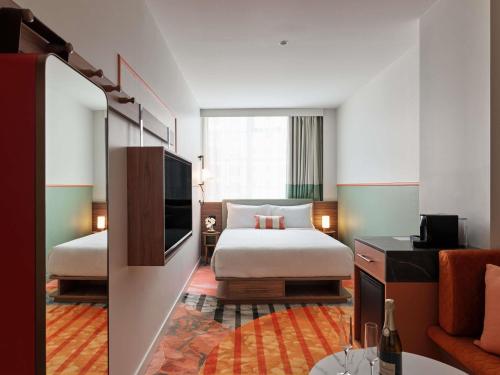 een hotelkamer met een bed en een televisie bij The Clarence Hotel Sydney in Sydney