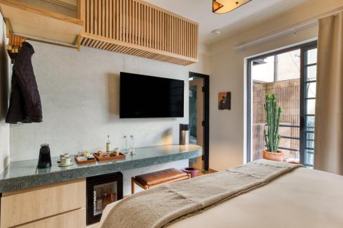a bedroom with a bed and a tv on the wall at Rodona Hotel in Mexico City